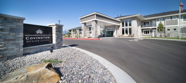 Assisted living in Heber exterior at Covington Senior Living with covered entrance, stone facade, and community sign.
